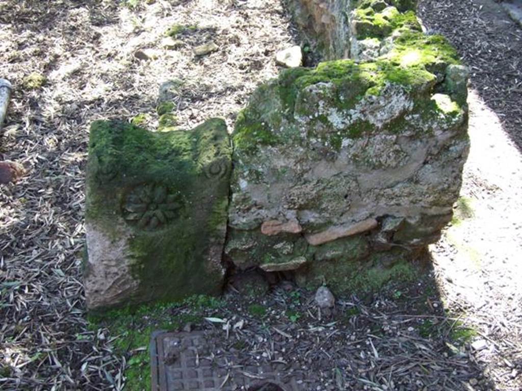 I.12.8 Pompeii. March 2009. Room 9. Peristyle garden. Low wall separating portico from garden, with decorated stone.