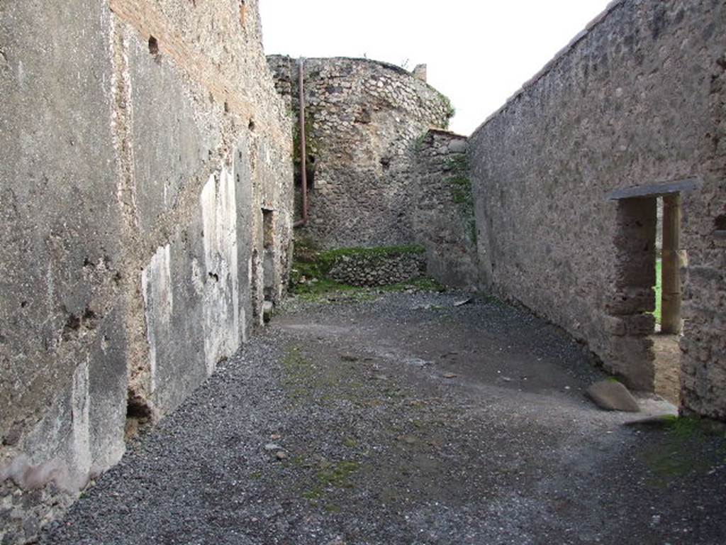 VII.1.8 Pompeii. December 2007. Room 8, anteroom of women’s baths, looking south from changing room 11. Doorway leading to praefurnium 7 is on left. Doorway to east portico B and gymnasium C is on right. According to Boyce, on the east wall (left), was a painted single serpent coiling towards an altar with offerings. He described it as being above the small arched opening that passed the conduit that supplied water for the labrum of the women’s calidarium 9. This would be somewhere in the vicinity of the large white patch on the wall. See Boyce G. K., 1937. Corpus of the Lararia of Pompeii. Rome: MAAR 14. (p. 95, 472).