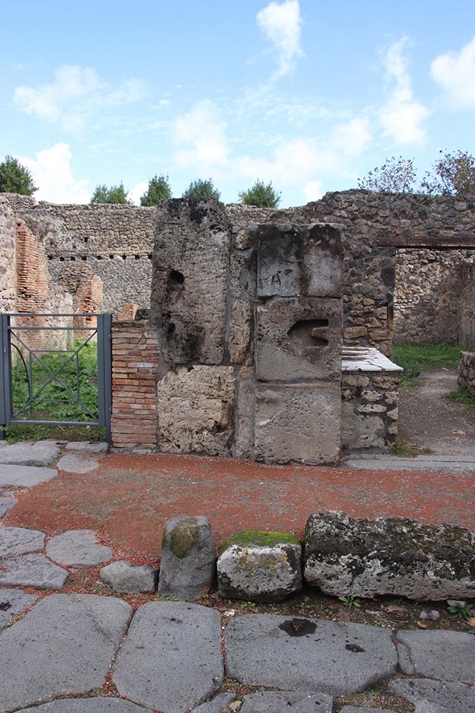 I.1.2 Pompeii, on right. October 2024.
Pilaster on east side of Via Stabiana between I.1.3, on left, and I.1.2. Photo courtesy of Klaus Heese.