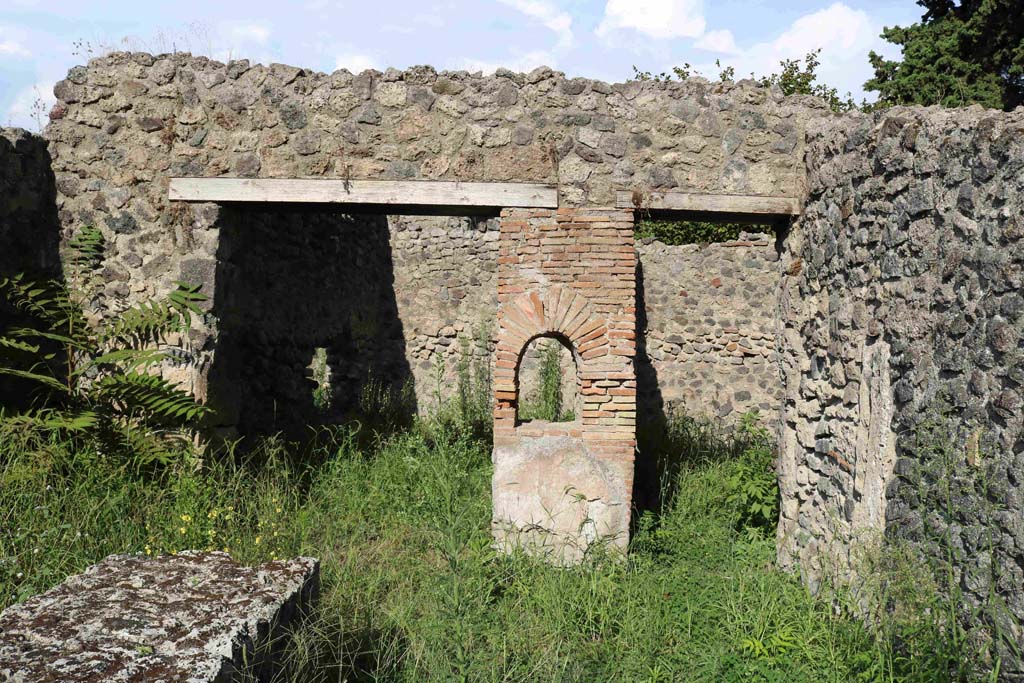 I.1.2 Pompeii. September 2018.
Looking east, at front, remains of podium in selling room. At the rear are entrances to two rear rooms. Photo courtesy of Aude Durand.