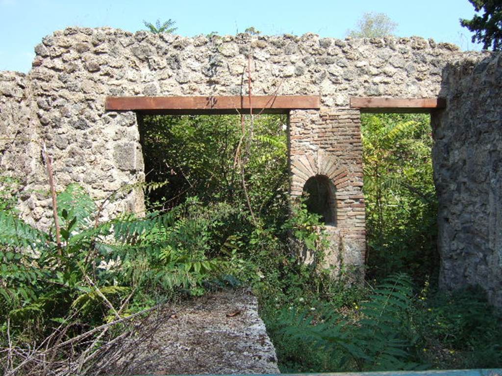 I.1.2 Pompeii. September 2005. In front, remains of podium in selling room.
At the rear are entrances to two rear rooms. The one on the left (north side) was the dining room for the customers and had painted walls, where one could have a glimpse of Phryxus sitting on a ram, extending his hand to Helle to pull her from the waves.
The other larger rustic room, on the south, contained the kitchen with hearth, the latrine and steps to the upper floor dwelling.
See Pappalardo, U., 2001. La Descrizione di Pompei per Giuseppe Fiorelli (1875). Napoli: Massa Editore. (p.33)