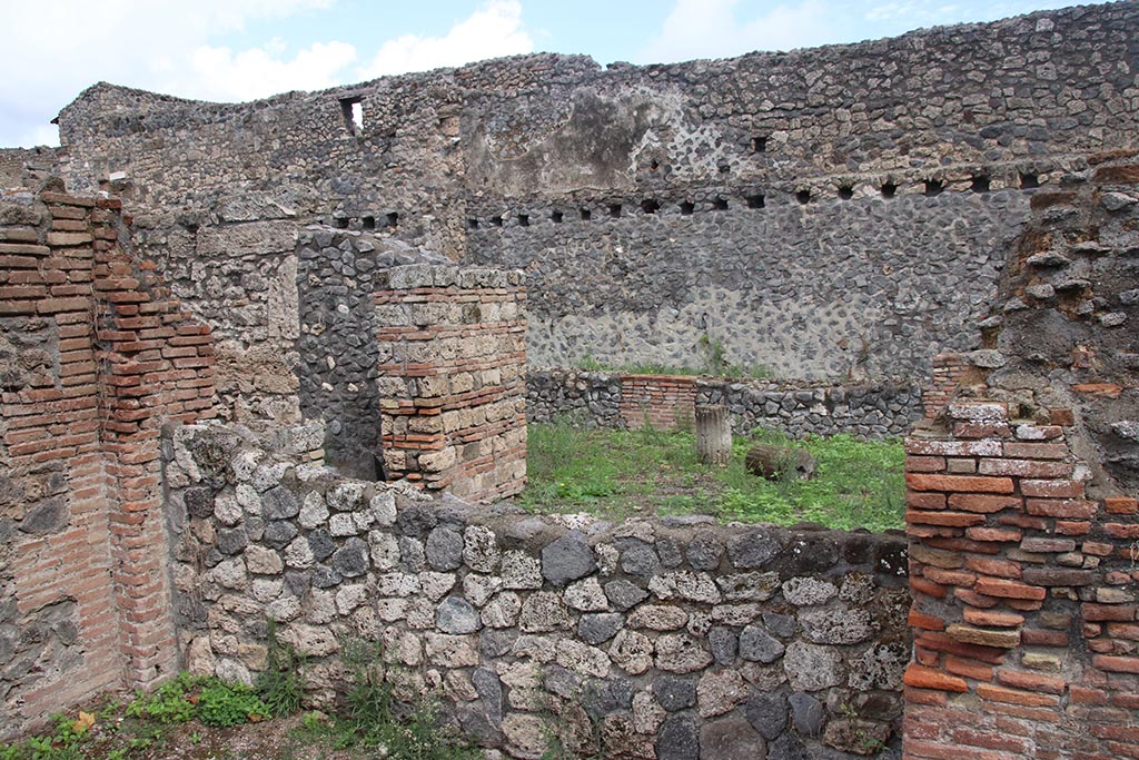 I.1.4 Pompeii, October 2024.
Looking east across rear wall of rear room of I.1.4, towards north side of yard “c”, with doorway into room “e”. Photo courtesy of Klaus Heese.