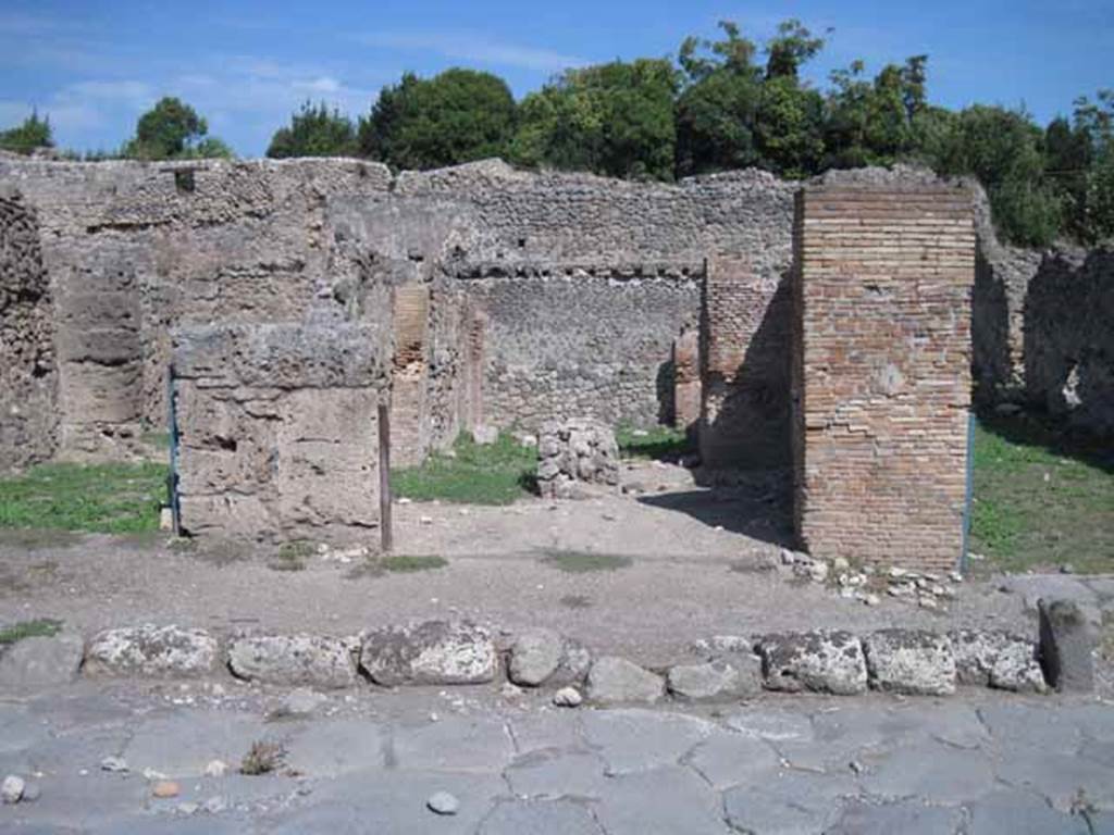 I.1.4 Pompeii. September 2010. Entrance, looking east east from Via Stabiana.Photo courtesy of Drew Baker.
According to Warscher, quoting Mau in Bull. Inst. 1875, p.29,
I.1.4/5 - “Mentre le località servivano per i carri e per il bestiame da tiro e come camere da letto, lungo la strada, a sinistra dello ingresso, stanno altre località (nos.4 and 5) che evidentemente servivano da caupona per i carrettieri e per altri avventori. Vi sono due locali con larga apertura sulla strada, a guisa di botteghe, congiunte mediante una porta, e in ciascuno di cui dà un’altra stanza con apertura larga anch’essa, queste ultime non congiunte fra di loro, mentre quella meridionale ha una porta su quel locale per cui si passa nel cortile. In mezzo al locale anteriore no.4 si trova una tavola di materiale piuttosto piccola, sulla quale si metteva senza dubbio una tavola più grande di legno per mangiare. Avanti alla porta del locale no.5 e lungo il muro laterale della casa adiacente, che sporge un poco nella strada, vi è una panca di materiale, quale trovammo avanti alla caupona (also see I.1.6/9)
See Warscher T., 1936. Codex Topographicus Pompeianus: Regio I.1, I.5. (no.13), Rome: DAIR, whose copyright it remains.
(translation: “While the locality served for wagons and animals and as sleeping accommodation, along the road, to the left of the entrance, were other places (nos. 4 and 5) that evidently served as caupona for the carters and other patrons. There were two rooms with a wide opening onto the road in the guise of shops, joined through a door, and in each of which had another different room also with a wide opening, these last did not join each other, while the southern one had a door which passed into the courtyard. In the middle of the front room of no. 4 was a table of material, rather small, on which one would undoubtedly have placed a larger wooden table for eating. Before the door of the premises no. 5 and along the side wall of the adjacent house, which protruded a little into the street, there was a bench of material, which was found before the caupona”.)
