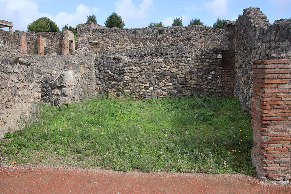 I.1.6 Pompeii. October 2024.
Looking east across shop-room, with doorway in north wall into I.1.8, on left. Photo courtesy of Klaus Heese.