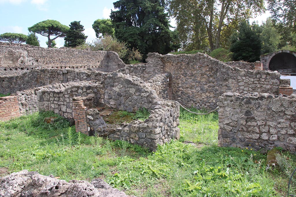 I.1.8 Pompeii. October 2024.
South wall of entrance room, with hearth, in centre, and doorway leading to I.1.6, on right. Photo courtesy of Klaus Heese.