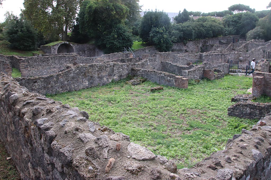 I.1.8 Pompeii. October 2024.
Rear of hospitium, looking south-west across I.1.8 towards Stabian Gate, from Vicolo del Conciapelle. Photo courtesy of Klaus Heese.