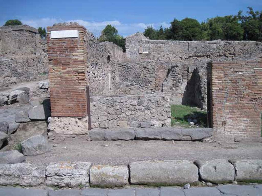 I.1.9 Pompeii. September 2010. Entrance doorway, looking east from Via Stabiana.
Photo courtesy of Drew Baker.
According to Warscher, quoting Mau in Bull.Inst 1875, p.30, I.1.6-9: “Segue un altro albergo, molto simile a questo descritto. Qui pure è interrotto il marciapiede per lasciar entrare i legni. L’entrata era chiuse mediante una porta a quattro partiti, congiunti a due adue, come si conosce dai quattro buchi per i chiavistelli. Qui pure si entra prima in un compreso che ha le dimensioni d’una bottega grande con una dietrobottega e posteriormente si apre sopra una grande corte, lungo il cui muro di fondo qui pure si stende la stalla, larga 13,30, profonda 2,47 con una finestra sul vico settentrionale e due porte, una all’estremità meridionale, l’altra poco distante da quella settentrionale.
Presso a quest’ultima una parte della corte è selciata. Lungo il muro N vi sono due camere con finestre sul medesimo vico, e prossimo alla stalla il cesso. Si vede anche il cesso del piano superiore e i tubi di mattone d’un terzo, che stava ancora più in alto.
Nell’angolo NO vi sono I primi gradini d’una scala, la cui parte superiore sarà stata di legno, in quello SO l’apertura della cisterna, e accanto nella stessa massa di materiale una vasca lunga stretta e bassa, come quella sudescritta nella casa adiacente. Qui la vediamo frapposto fra la cisterna ed il muro di O, il che esclude categoricamente l’aver essa servito d’abbeveratoio. Dalla parte più bassa di essa, aperta come nella casa sudescritta, l’acqua colava in un’altra vasca larga 1,02 x 1,54, di cui un lato viene formato dalla suddetta massa di fabbrica, uno dal muro occidentale, i due rimanenti da appositi muricciuoli. Essa ha al fondo uno scolo verso N, che dà in un vaso ossia tubo di mattone, incastrato nel suolo.Nella parete vi era la pittura dei Lari, di cui sono rimasti soltanto i serpi.A destra dell’ingresso per i legni sta un locale come una bottega.
L’essere esso congiunto mediante una porta con quel primo compreso, ove entravano i legni, ci lascia supporre, aver esso servito di caupona per i vetturini”.
See Warscher T., 1935. Codex Topographicus Pompeianus: Regio I.1/I.5. Rome: DAIR. (no.14)
(for a translation see, I.1.6).