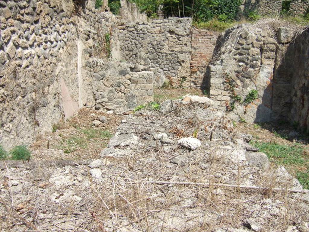 I.1.9 Pompeii. September 2005. Looking east to rear room. In front, remains of two-sided counter with hearth and built-in Dolium.