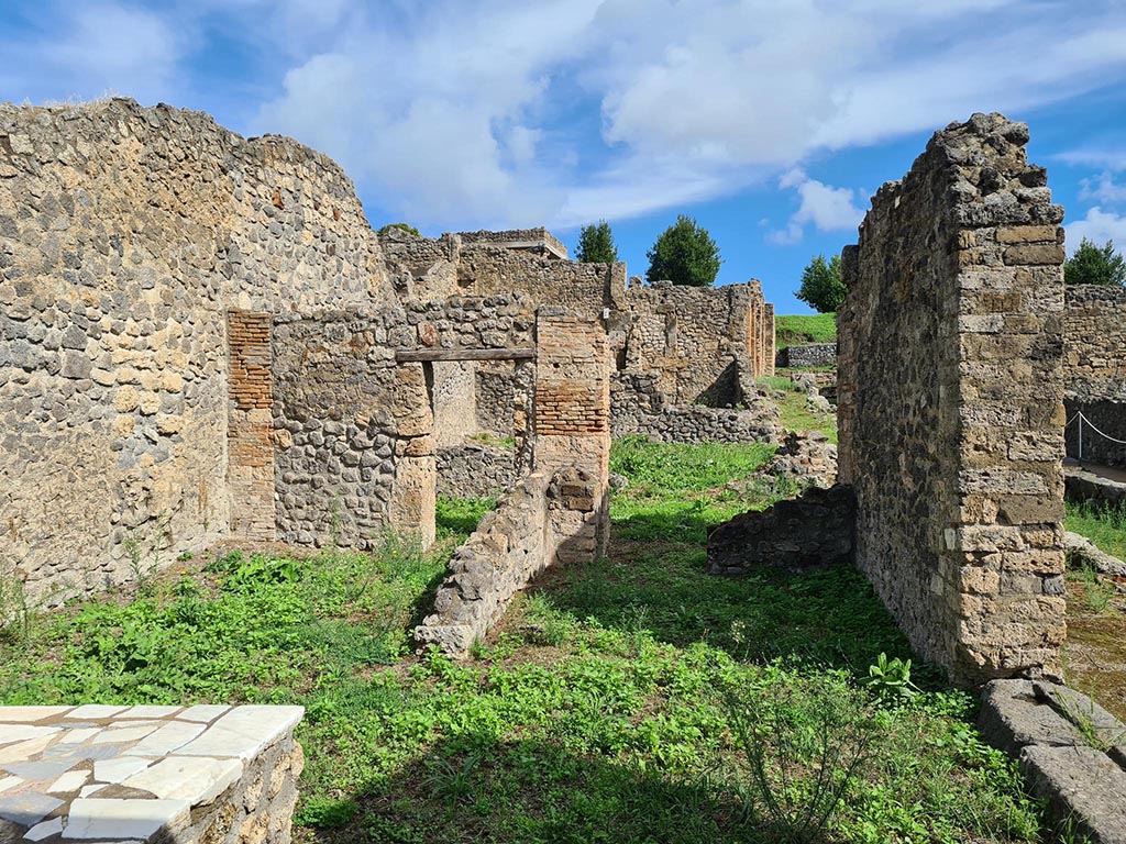I.2.1 Pompeii. October 2024.
Looking east across bar-room towards rear rooms leading into I.2.31, with doorway at I.2.32, on right. Photo courtesy of Klaus Heese.