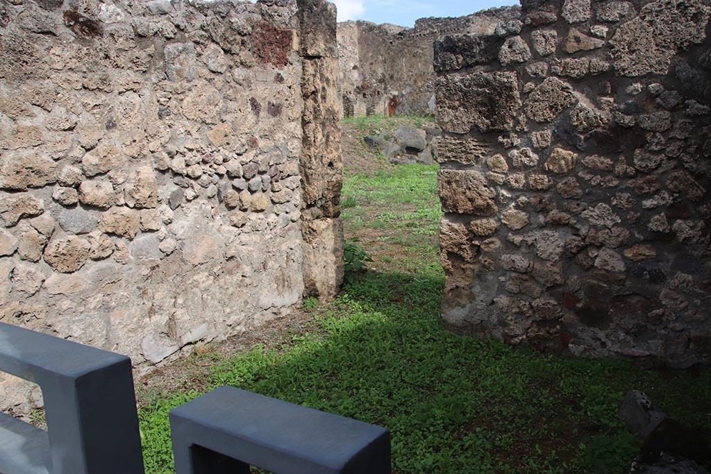 I.2.2 Pompeii. October 2024.
Looking towards north wall of shop-room, with doorway to atrium of I.2.3 in east wall at north end. Photo courtesy of Klaus Heese.