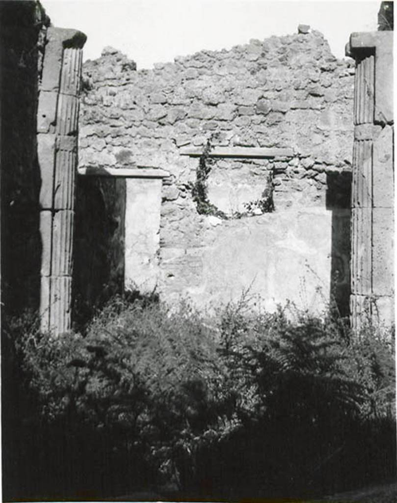 I.2.3 Pompeii. 1935 photo taken by Tatiana Warscher. Looking north.
Warscher described this photo as – I.2.3 “Il triclinio (h): una specie di piccolo vestibulo a sinistra (nord) è ornato con due mezzocolonne di tufo scannelate. Non è rimasto niente nè della pittura del Genio familiare che libava, nè del dipinto del gallo sull’ara. In connessione con la colonna intercalata nel muro nord della prima camera a sinistra dell’atrio (photo no.8) facciamo attenzione che nel muro occidentale del triclinio sono intercalati due tamburi d’una colonna. Forse il proprietario ricostruendo la casa dopo il terremoto dell’anno 63 ha acquistato una colonna, due tamburi e anche due mezzocolonne scannellate.
Quoting Sogliano, no.58 on page 18, she described: Cella penaria: “Serpente che si accosta all’ara imbandita di offerte; al di sotto piante palustri e al di sopra tre piccoli festoni di foglie, sormontati ciascuno da un uccelletto”.
See Sogliano, A., 1879. Le pitture murali campane scoverte negli anni 1867-79. Napoli: Giannini. (p.18, no.58)
See Warscher T., 1935. Codex Topographicus Pompeianus: Regio I.2. (no.11), Rome: DAIR, whose copyright it remains.
(translation: I. 2.3 "triclinium (h): a small vestibule on the left (north side) was adorned with two fluted tufa half-columns. There remained nothing of the painting of the family Genius making the offering, nor of the painting of the cock painted on the altar. In connection with the column inserted in the northern wall of the room to the left of the entrance hall (photo no. 8) we draw attention that in the west wall of the triclinium were interspersed two column drums. Maybe the owner by rebuilding the house after the earthquake of the year 63 had bought a column, two drums and also two fluted half-columns”.
Quoting Sogliano, no. 58 on page 18, she described:
Storeroom : "Serpent approaching the altar table laid with offerings; marsh plants below and three small garlands festoons of foliage above, each surmounted by a bird”.)