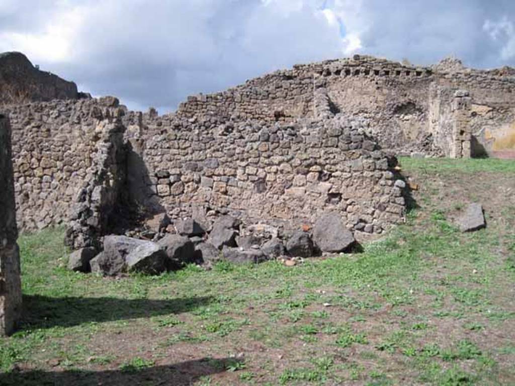 1.2.3 Pompeii. September 2010. Looking north towards remains of north wall (left or north-western corner of atrium). The shop at I.2.4 is on the left behind the wall. The north wall of house at I.2.6 can be seen at the rear. Photo courtesy of Drew Baker.