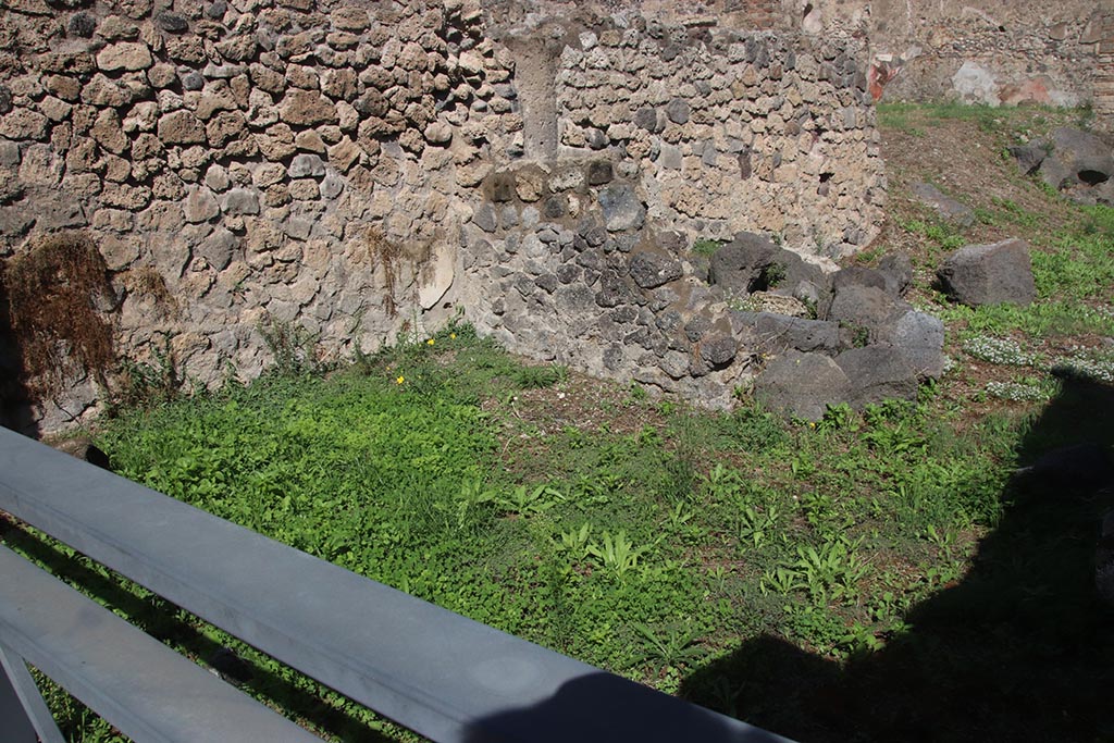 I.2.4 Pompeii. October 2024.
Looking towards north wall of shop-room, with north-west corner of atrium of I.2.3, behind low ruined wall. Photo courtesy of Klaus Heese.