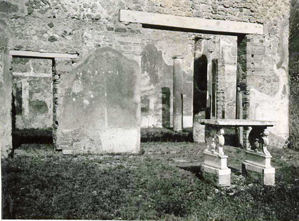 1.2.6 Pompeii. 1935 photo taken by Tatiana Warscher. Looking towards east wall of atrium, with two doorways leading to portico of peristyle. Warscher quoting Mau in BdI, 1874, p.199, described –
I.2.6 “L’atrio toscanico offre poco interesse. Sul lato orientale dell’impluvio sta una tavola di marmo, sorretta da due sostegni su basi murate. I sostegni sono formati ciascuno da due grifi, una con testa di leone, l’altro di cavallo. Sul piano che resta libero fra’grifi in ciascun de’lati esteriori, è rapresentato il vaso con coperchio alto ed appuntato e due ornamenti che hanno la forma di teste d’acquila, in ciascuno dei lati interiore un cornucopia con frutta.”
See Warscher T., 1935. Codex Topographicus Pompeianus: Regio I.2. (no.14), Rome: DAIR, whose copyright it remains.
(translation: the Tuscanic atrium offers little of interest. On the eastern side of the impluvium was a marble table, held up by two supports on brick bases. Each of the supports were formed from two griffins, one with the head of a lion, the other with a horse’s head.
On the side edge that remained free between the griffins, on each of the exterior sides was represented a vase with a tall lid and two ornaments that have the shape of an eagle heads, in each of the interior sides a cornucopia with fruit.")
According to Bragantini, in the atrium two marble table legs were photographed. The two griffin supports were included, but the two pegasus supports had been transferred.
See Bragantini, de Vos, Badoni, 1981. Pitture e Pavimenti di Pompei, Parte 1. Rome: ICCD. (p.1)