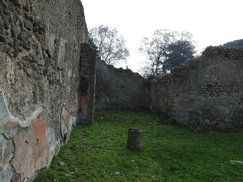 I.2.6 Pompeii. December 2006. East wall of peristyle, looking south to triclinium.
Traces of original plaster can still be seen on the east wall of the peristyle.
When excavated this could be seen as painted in red and divided in compartments by gold coloured candelabra.
Photographs by Tatiana Warscher of this area can be seen in - Garcia y Garcia, L., 2006. Danni di guerra a Pompei. Rome: L’Erma di Bretschneider. (p. 39)
When excavated the triclinium had 3 large paintings.
However, one fell together with its wall, another which showed Meleager at the hunt of the Calydonian boar remained slightly visible on the east wall (now faded) and the one most intact was sent to Naples Archaeological Museum, (NAP inventory number 109751, The theft of the Palladium), at the side of which were two medallions showing female busts crowned with foliage of vine leaves and herbs.
These were found on the south wall.
A medallion of a young person crowned with vine foliage was found on the south wall.
See Pappalardo, U., 2001. La Descrizione di Pompei per Giuseppe Fiorelli (1875). Napoli: Massa Editore. (p.35)