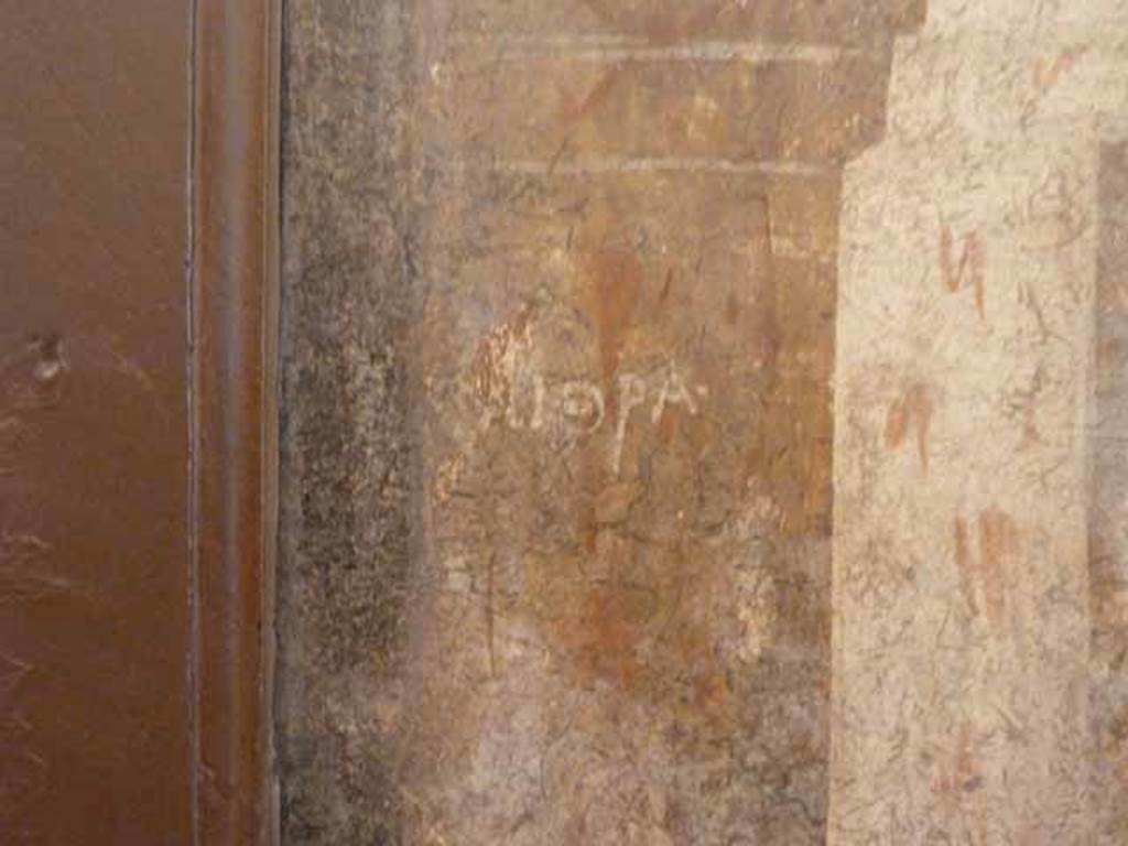 I.2.6 Pompeii. May 2010. Detail from the wall painting of the Theft of the Palladium (Ratto del Palladio) found on the south wall of the triclinium. Name on column base. Now in Naples Archaeology Museum, inventory number: 109751