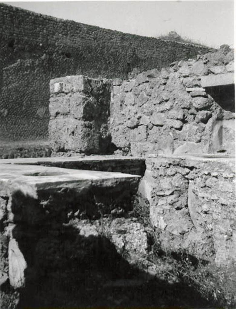 I.2.8 Pompeii. 1935 photo taken by Tatiana Warscher. Looking north-west across bar-counters towards north wall with niche. Warscher described –
I.2.8 “una taberna col podio continente due urne altre il focolaio, ed altro podio da un lato, in qui stanno infisse tre urne di maggiore dimensione:
un muro divideva questo primo compreso da un secundo più interno, ove sembra fossero collocati due letti, e serviva anche di sostegno ad una scala, che portava alle stanze sovrapposte”.
See Warscher T., 1935. Codex Topographicus Pompeianus: Regio I.2. (after no.20), Rome: DAIR, whose copyright it remains.