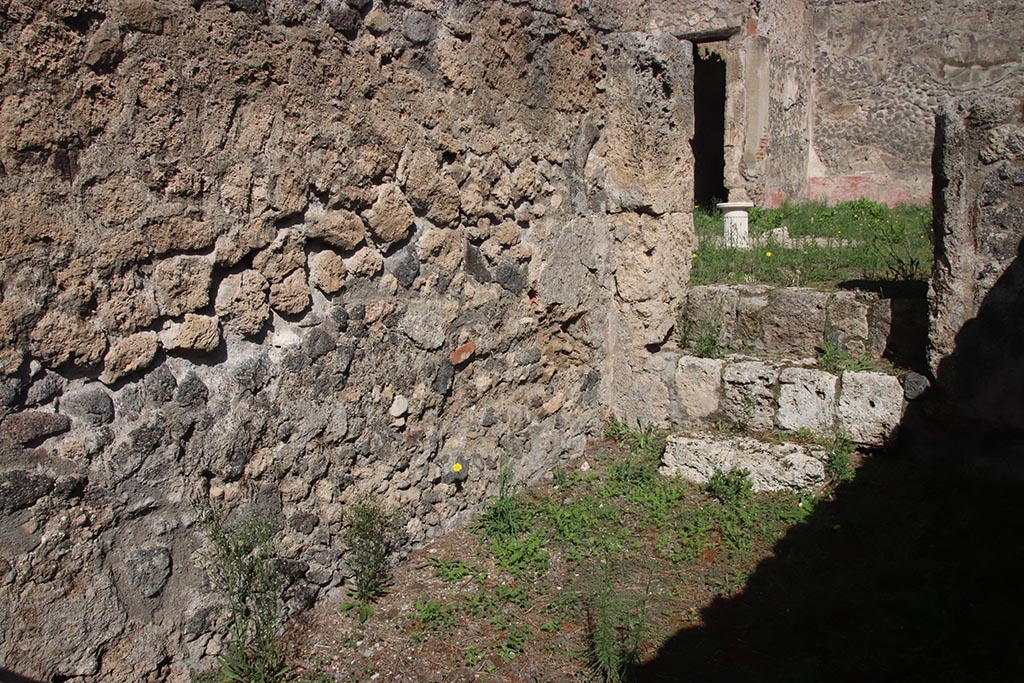 I.2.9 Pompeii. October 2024.
North wall in north-east corner, with three steps in east wall into atrium of I.2.10. Photo courtesy of Klaus Heese.