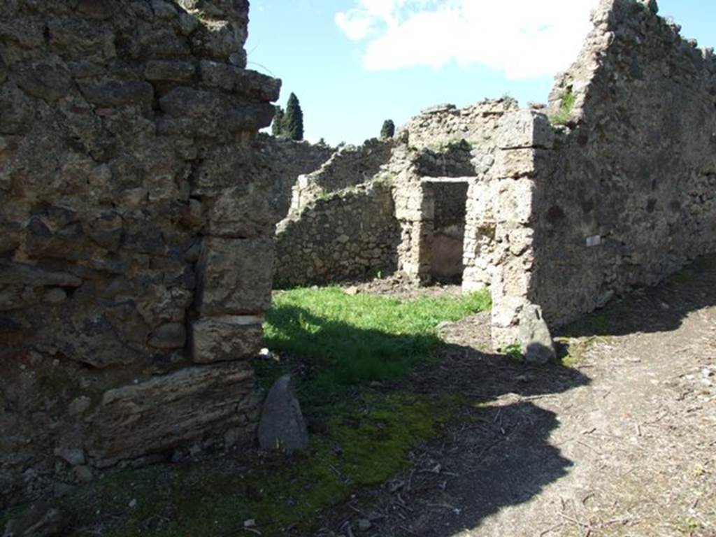 I.2.22 Pompeii. March 2009. Entrance, looking north-west. According to Warscher, quoting Mau in Bull. Inst. 1874, p.263, she described – I.2.22 “Le case che verso E danno sul vico di Tesmo, non meritano una descrizione dettagliata. Rilevo soltanto che nella prima casa verso S a destra d’uno stretto corridoio si trova prima un bacino murato rotundo (diam. 0,50 – 0,58), poi un altro quadrangolare (I,82 + 0,70), che tocca quel primo col lato corto. Ambedue sono profondi 0,82 e congiunti presso al fondo da un foro; dal secondo l’acqua scolava verso S. In fondo al sudetto corridoio vi è la cucina, col focolare a destra fra cui e quei bacini il muro è perforato da una piccola finestra.
In una camera della stessa casa leggiamo nel pavimento in pietruzze bianche la parola “HAVE”.
See Warscher T., 1935. Codex Topographicus Pompeianus: Regio I.2. Rome: DAIR.
(translation: I. 2.22 "The house that overlooked the vico di Tesmo to the east, doesn’t deserve a detailed description. I note only that in the first house towards the south, to the right of a narrow corridor, one found first a walled round basin (diam. 0,50 – 0,58), then another quadrangular (1,82 + 0,70), which touched against the first with its short side. Both were 0,82 deep, and joined towards the back by a hole; from the second the water drained off towards the south. At the bottom of the same corridor there was the kitchen, with stove on the right, between which and some basins, the wall was pierced by a small window. In a room of the same house we read the word “HAVE” written in white stones on the floor.”)