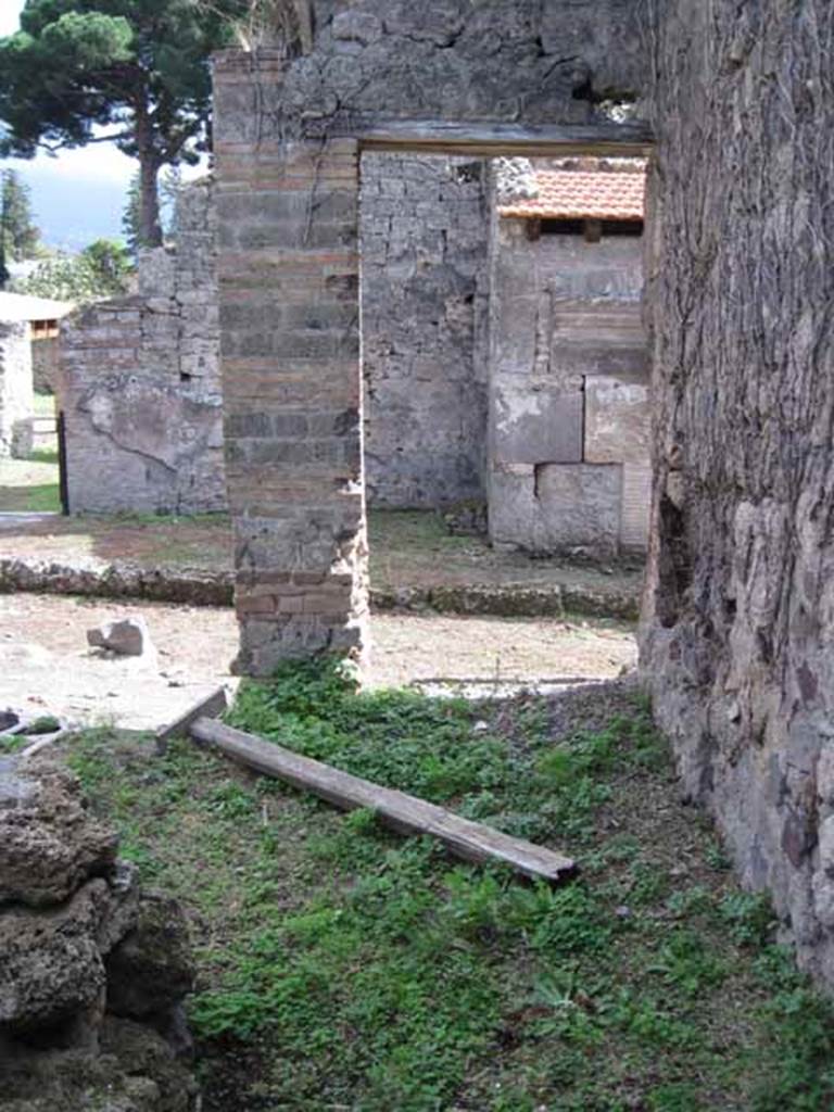 I.2.25 Pompeii. September 2010. Looking south along west side, towards entrance doorway of I.2.26 on Vicolo del Conciapelle. Photo courtesy of Drew Baker. This entrance would have been a separate stairs to an upper dwelling and workshop. Beneath the stairs would have been a latrine