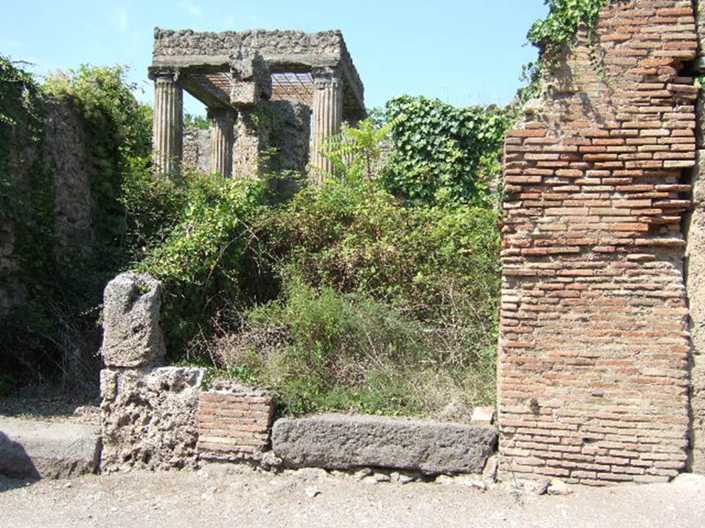 I.2.27 Pompeii. September 2005. Lava threshold or sill, leading to small room with steps to an upper floor. The room was linked at the rear, with the atrium of I.2.28. Fiorelli thought the steps could have led to a separate dwelling for a lodger or perhaps a caretaker. See Pappalardo, U., 2001. La Descrizione di Pompei per Giuseppe Fiorelli (1875). Napoli: Massa Editore. (p.37).