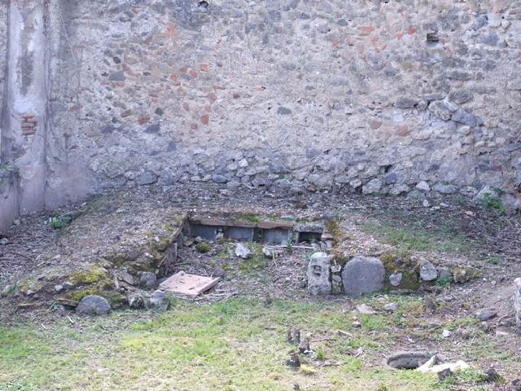 I.2.28 Pompeii. March 2009. Looking west towards garden triclinium.
Each couch had four niches on its inside wall. The four from the couch against the west wall are visible here. Taken from I.2.20. A second cistern-mouth can be seen on the right of the photo.