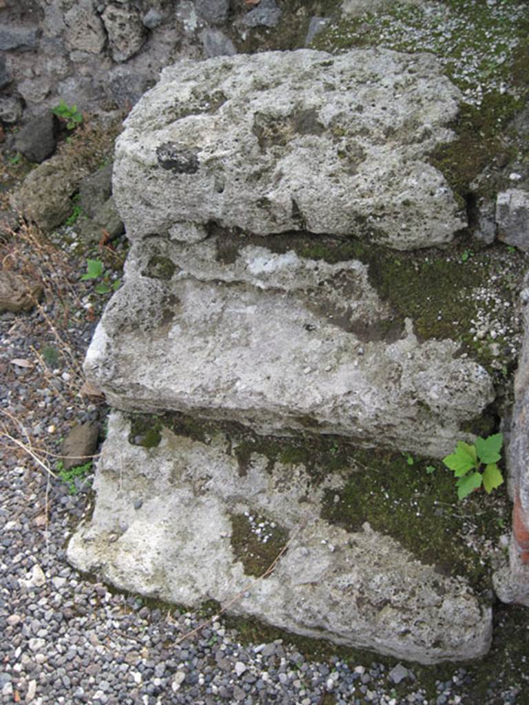 I.3.2 Pompeii. September 2010. Detail of stone steps against the south wall in south-west corner. Photo courtesy of Drew Baker.
According to Fiorelli, on the right of the entrance doorway was a staircase similar to the one in the preceding shop. He described that one as a wooden stepladder, reached by similar three stone steps. See Pappalardo, U., 2001. La Descrizione di Pompei per Giuseppe Fiorelli (1875). Napoli: Massa Editore. (p.38)