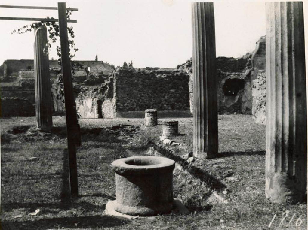 I.3.3 Pompeii. 1935 photograph taken by Tatiana Warscher from the north-east corner of the peristyle. To the right, the north portico with a pipe from the acqueduct. The pipe was also found along the west portico. The remains of the pipe of the acqueduct could be seen in both the north and west portico. In the north-west corner, on the right, the recess for the triclinium couch can be seen. The house can be found opposite the theatres.
See Warscher, T, 1935: Codex Topographicus Pompejanus, Regio I, 3: (no.10a), Rome, DAIR, whose copyright it remains.
According to Jashemski, quoting Mau, there were two cistern openings, one in the north-east corner of the garden, with a tufa puteal, the other opening in the corresponding corner of the portico. Water emptied at the north-east corner from the gutter into the cistern and into the street at the south-east and south-west corners. Between the gutter and the portico there was an aqueduct pipe which came out of the first column, counting from the south, on the west portico. Supporting itself on the second column on the west side, the pipe rose to give a jet of water in the gutter. Flanking the west portico and the one to the north, it disappeared towards the north-east. Twice, on the west side, by a widening of the pipe, it was possible to let water flow into the gutter.
The gutter at precisely these two points had openings towards the garden which the apparatus served to water. Before and after the widening of the pipe, it could be closed by a key. Two branches of this pipe entered the room in the Subterannean Level in which there was a tank, off the north-west corner of the peristyle.
See Mau, BdI, 1874, pp.181-182.
See Jashemski, W. F., 1993. The Gardens of Pompeii, Volume II: Appendices. New York: Caratzas, (p.26).