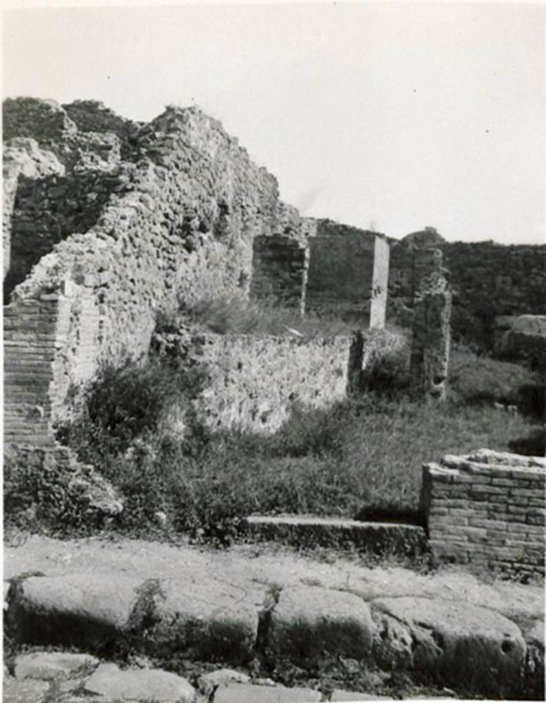 I.3.10 Pompeii. 1935 photograph taken by Tatiana Warscher, looking east towards entrance from Via Stabiana.
See Warscher, T, 1935: Codex Topographicus Pompejanus, Regio I, 3: (no.26), Rome, DAIR, whose copyright it remains.
According to Warcher, “This was a workshop with other rooms, altered from the ancient configuration by the route of the Sarno canal built by Fontana: here one can see the remains of wash-tubs and furnaces that existed here before”.