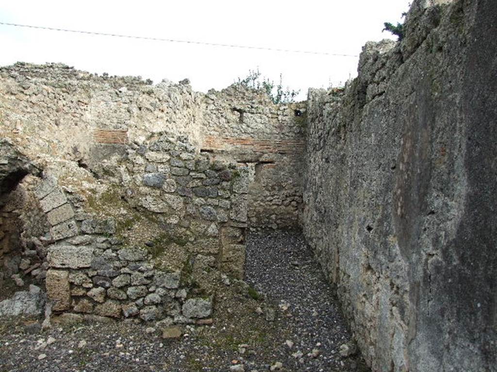 I.3.24 Pompeii. December 2006. Steps to upper floor, kitchen doorway and rear, south wall of house. According to Boyce, on this south wall of the peristyle was the Lararium painting. He described - The Genius, holding cornucopia against his left shoulder, poured a libation upon an altar from a patera held in his right. Beside him stood a Camillus holding a shallow dish. Opposite the Genius were the tibicen and the popa, the latter leading a pig to sacrifice. Only the Lar on the right remained.
In the lower zone, a single red and yellow serpent coiled towards an altar. Nothing now remains of this painting in situ.
See Boyce G. K., 1937. Corpus of the Lararia of Pompeii. Rome: MAAR 14. (p. 24)