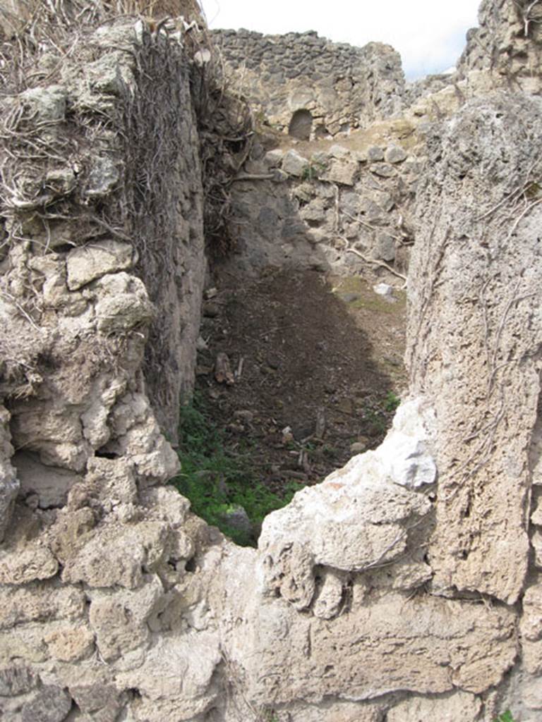 I.3.27 Pompeii. September 2010. Looking north from I.3.3 towards reverse of south-west corner of the above room. Drew Baker says – the photo was taken to compare form of the aperture.
The eastern side appears to have a tufa framing member and the base at least a partial threshold however there is no corresponding part on the western side which I would expect. However there is a wall there so it may not have been necessary but as there is what appears to be original fill either this is a door which was blocked up at some point or it is a feature of construction (opus africanum perhaps).
Photo courtesy of Drew Baker.