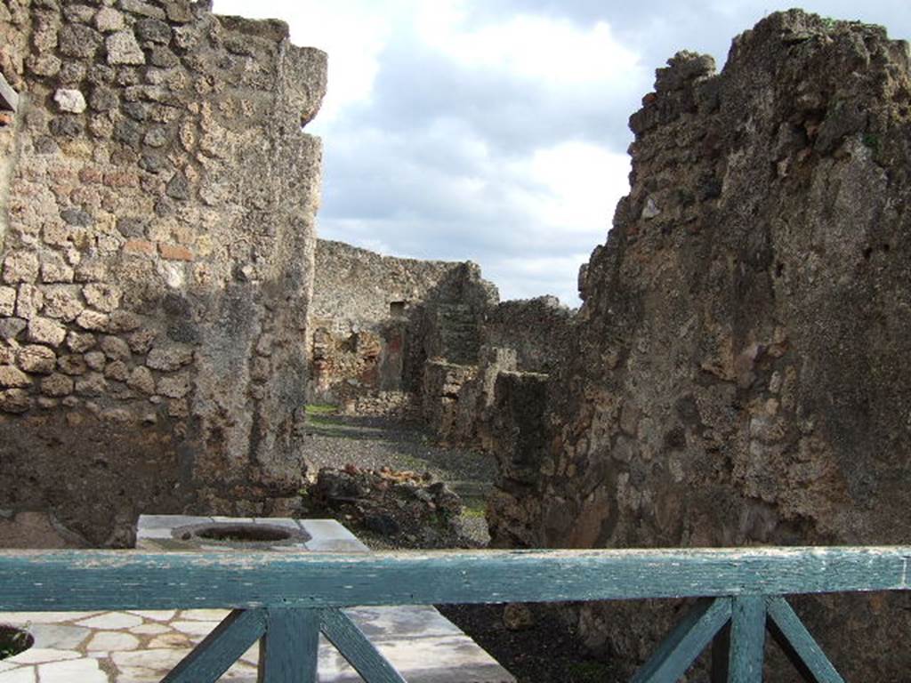 I.4.2 from I.4.3 Pompeii. May 2005. The remains of a hearth in the atrium can be seen by looking over the counter.