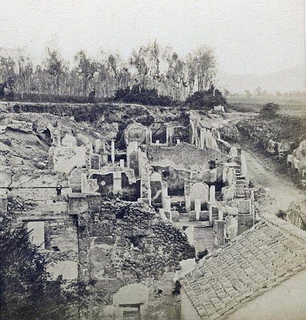 I.4.2 Pompeii. Detail from stereoview by R. Rive, c.1860-1870’s.
Looking across atrium towards peristyle at rear, and steps in south-east corner (all above the rebuilt roof in the right hand lower corner of the picture).
At the rear of the east wall of the peristyle would be the lower (third) peristyle of 1.4.5/25.
Photo courtesy of Rick Bauer.