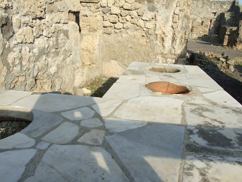 I.4.3 Pompeii. December 2007. Looking north-east across marble counter with three urns.