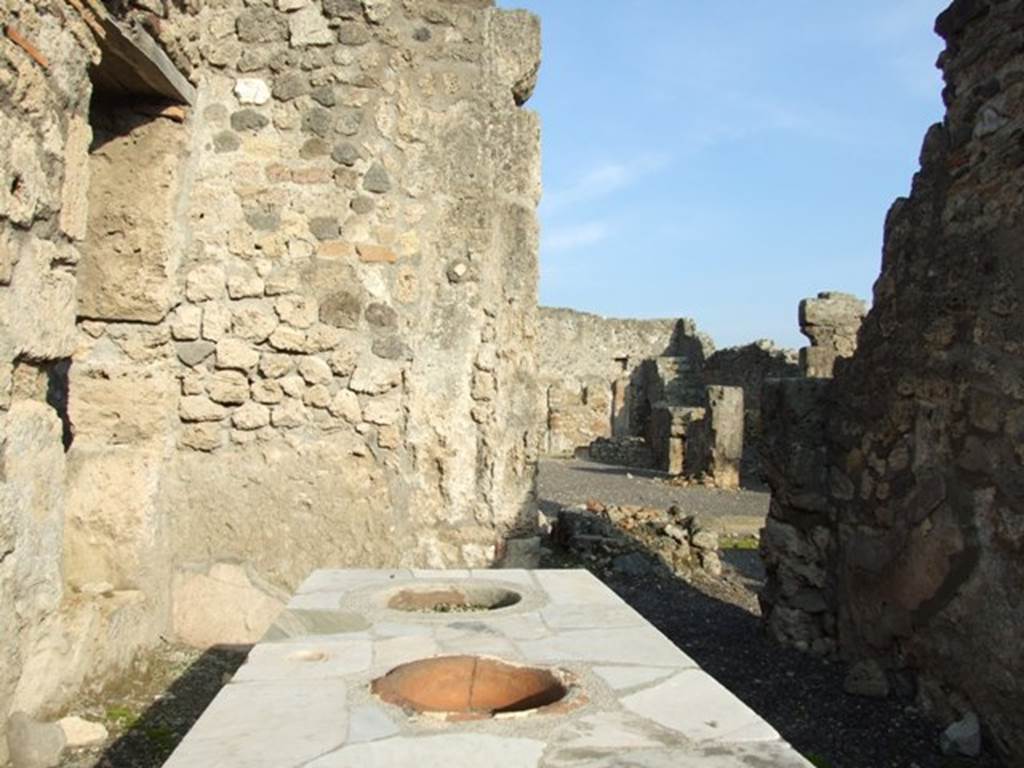 I.4.3 Pompeii. December 2007. Marble counter . In the east wall at the rear, the doorway leads into the atrium of I.4.2.