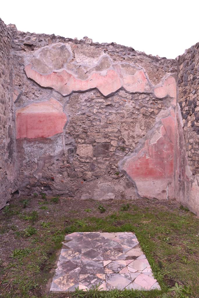 I.4.9 Pompeii. October 2019. Triclinium/oecus m, north wall.
Foto Tobias Busen, ERC Grant 681269 DÉCOR.
According to PPM –
„The north wall was perforated by explorers penetrating the house in search of materials useful for reconstruction after the eruption of 79AD, of the central aedicula in the rear wall only the triangular tympanum remained, which rises up to the upper red area punctuated by slender architectures.
With regard to the flooring, the position of the table in the middle of the three couches in the triclinium was given this carpet of squares and triangles of coloured marble.” (1977).
See Carratelli, G. P., 1990-2003. Pompei: Pitture e Mosaici. I. Roma: Istituto della enciclopedia italiana, (p. 180).