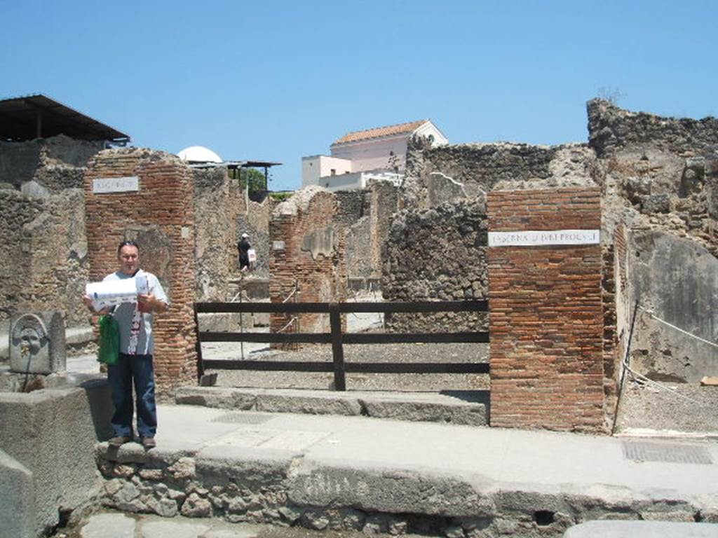 I.4.15 Pompeii. September 2005.  Looking north-east across shop, towards other entrance on Via dell�Abbondanza.  According to Fiorelli, on 9th December 1853, a bronze lamp was found with the name of the patron of the shop incised into an attached tablet:
DIVNI
PROQVLI
See Pappalardo, U., 2001. La Descrizione di Pompei per Giuseppe Fiorelli (1875). Napoli: Massa Editore. (p43)
The lamp is described as being of bronze with two wicks, incised with the name -
D(ecimi)  Iuni
Proquli  (CIL X 8071)
The lamp is now in the Naples Museum, inventory number 72166.
See Pagano, and Prisciandaro, R., 2006. Studio sulle provenienze degli oggetti rinvenuti negli scavi borbonici del regno di Napoli. Naples : Nicola Longobardi. (p.171) 
