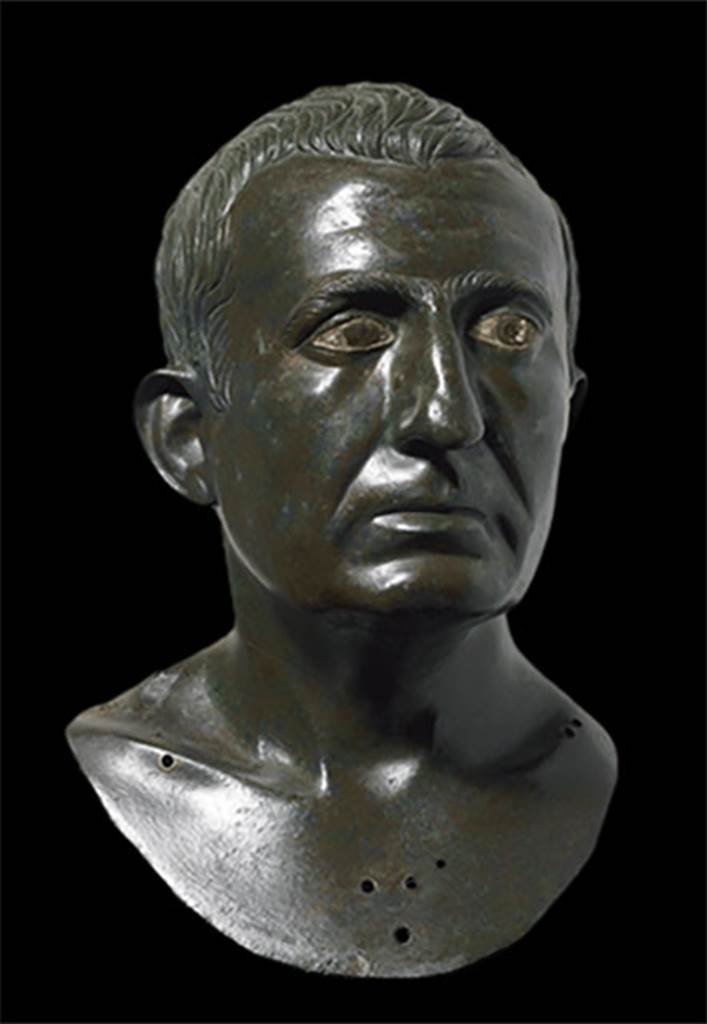 I.4.25 Pompeii. Atrium 6, floor of I.4.5 next to the tablinum, room 14.
Portrait bronze bust of a man presumed to be one of the owners.
It is one of a pair, placed on herms in the atrium on either side of the entrance to the tablinum.
Now in Naples Archaeological Museum. Inventory number 4989.