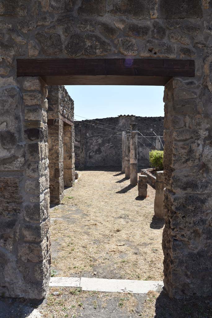 I.4.25 Pompeii. September 2020.
Lower Peristyle 32, looking south through doorway towards east portico, from Middle Peristyle 17
Foto Tobias Busen, ERC Grant 681269 DÉCOR.
According to Jashemski –
“The long wall separating the centre (Middle) peristyle from the south (Lower) peristyle has six windows and two doors which afforded a magnificent view into the southern peristyle. The six windows each corresponded to an intercolumniation in the southern peristyle, which would indicate that in the earlier period this peristyle had been considered the more important. The twenty columns of the portico were made of brick and Sarno limestone and faced with stucco. The upper parts were fluted, the lower parts were left plain. A marble puteal stood in the portico near the north-east corner column. A gutter outlined the edges of the garden.”
See Jashemski, W. F., 1993. The Gardens of Pompeii, Volume II: Appendices. New York: Caratzas. (p.31).