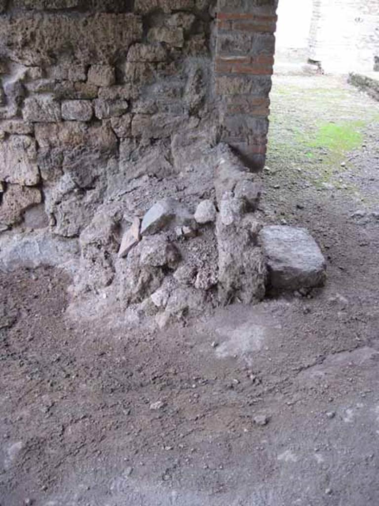I.5.2 Pompeii. September 2010. Looking north towards remains of masonry podium of lararium. Photo courtesy of Drew Baker.
According to Boyce, there was a ruined lararium in a room on the north-east side of the peristyle. It was a solid podium against the wall, with its three sides painted in imitation marble. There was a painted aedicula on the wall above it.
See Boyce G. K., 1937. Corpus of the Lararia of Pompeii. Rome: MAAR 14. (p.25)