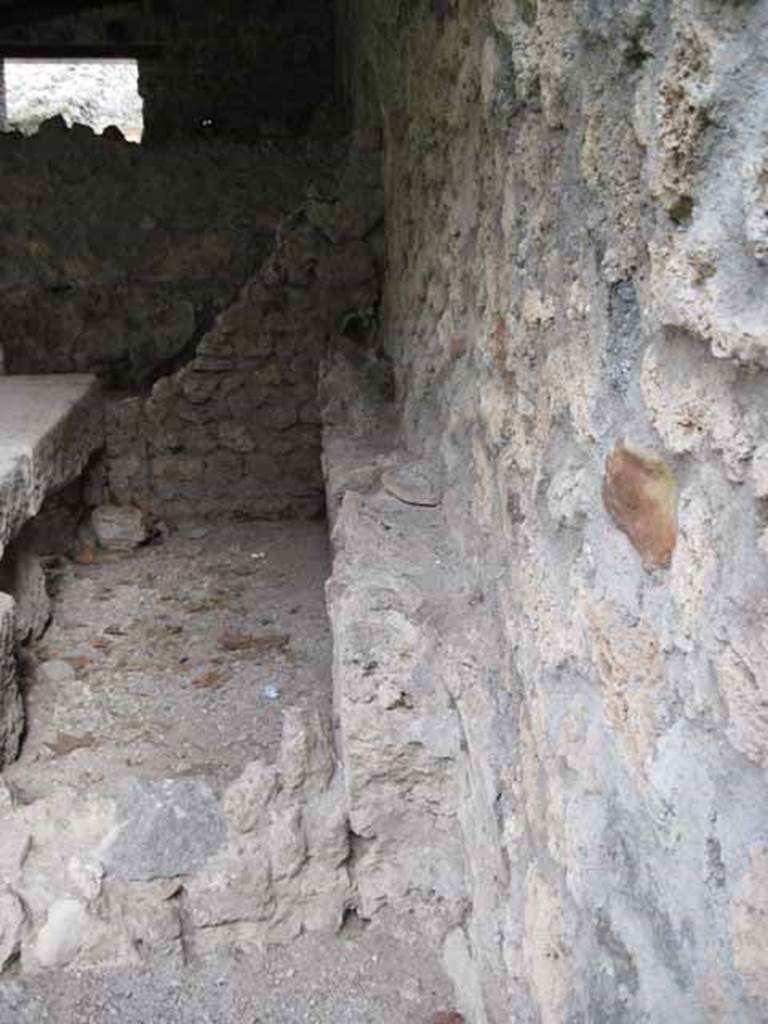 I.5.2 Pompeii. September 2010. Looking north along the east wall of the fourth and third divided compartments, showing pipe work. The north wall is in the background. Remains of the south dividing wall are in the foreground.
Photo courtesy of Drew Baker.