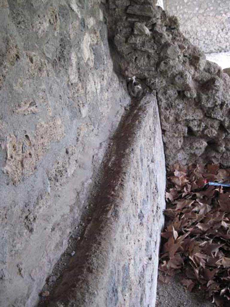 I.5.2 Pompeii. September 2010. View along the rear east wall, central bay, looking south towards wall showing pipe work. Photo courtesy of Drew Baker.