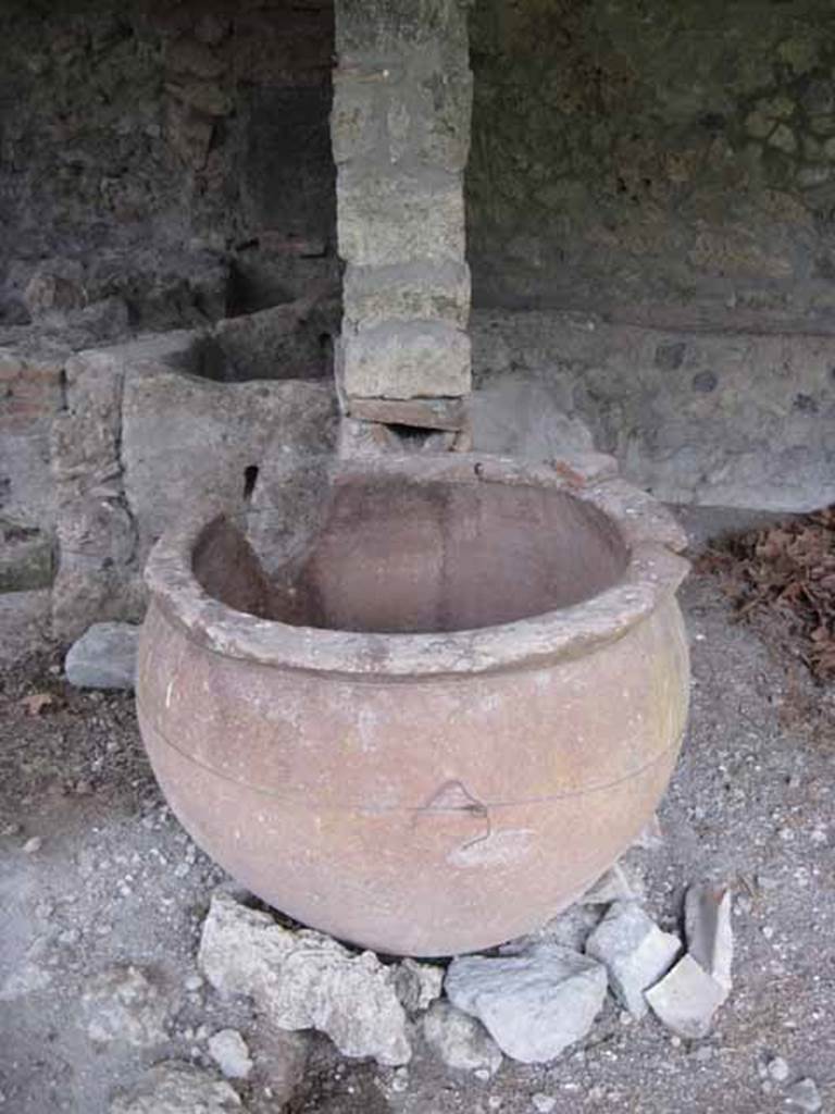 I.5.2 Pompeii. September 2010. Front on view of the dividing bay wall showing discharge pipe into pot. Photo courtesy of Drew Baker.