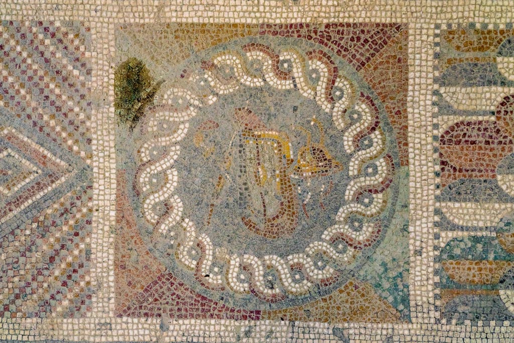 I.6.2 Pompeii. October 2023. Detail of mosaic panel with swords, shield and helmet. Photo courtesy of Johannes Eber.