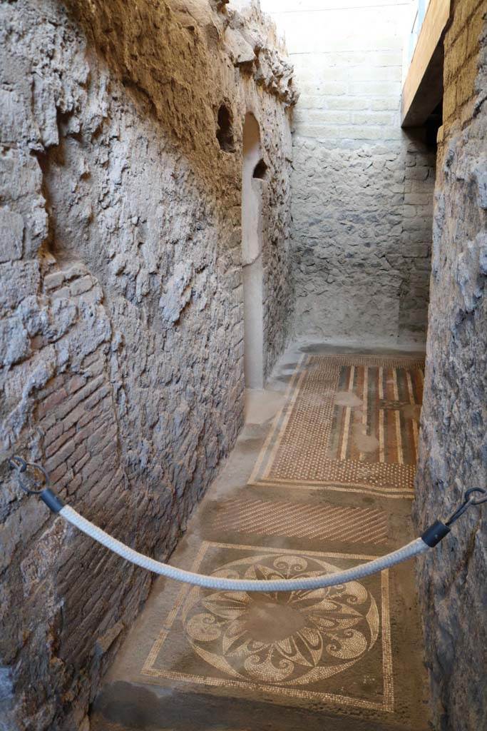 I.6.2 Pompeii. December 2018. Small doorway in east wall of east wing of cryptoporticus.
Looking east across ornate muti-coloured mosaic floors of anteroom, apodyterium or changing room, towards arched doorway to frigidarium, in centre.
Photo courtesy of Aude Durand.