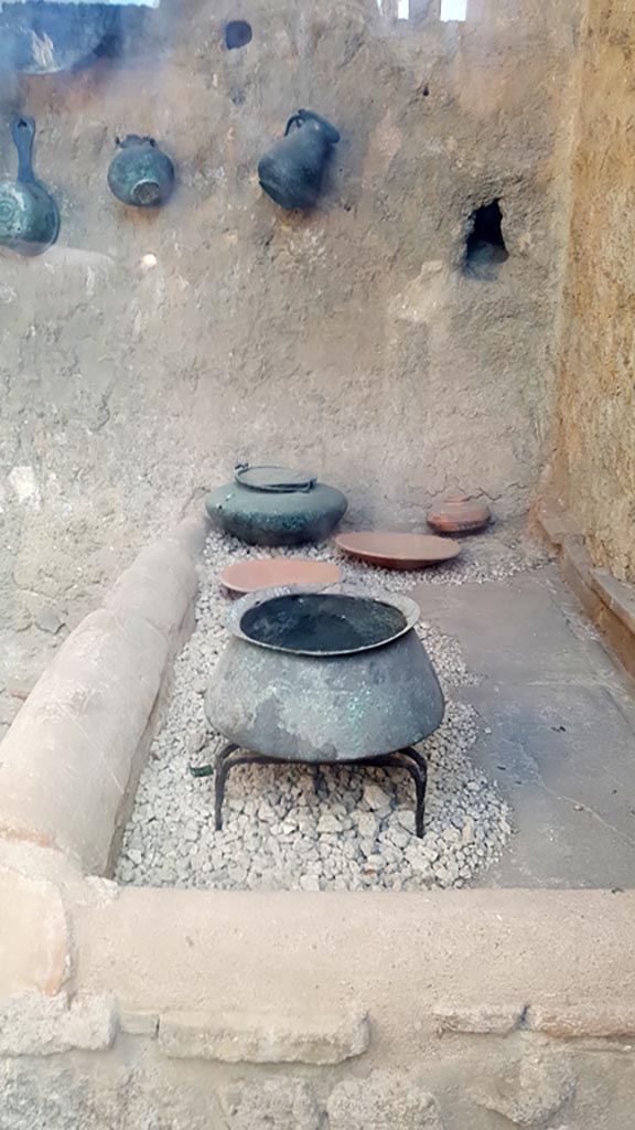 I.6.7 Pompeii. August 2023.
Looking south towards hearth at west end in kitchen with household utensils.
Photo courtesy of Maribel Velasco.