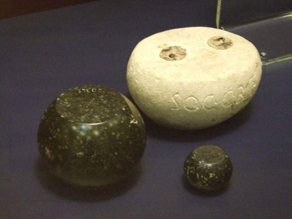 I.6.13 Pompeii. Round white limestone weight. SAP inventory number 3918.
The two other black basalt weights were found somewhere in Pompeii, the larger one has SAP 20349 on it.
Photographed at “A Day in Pompeii” exhibition at Melbourne Museum. September 2009.