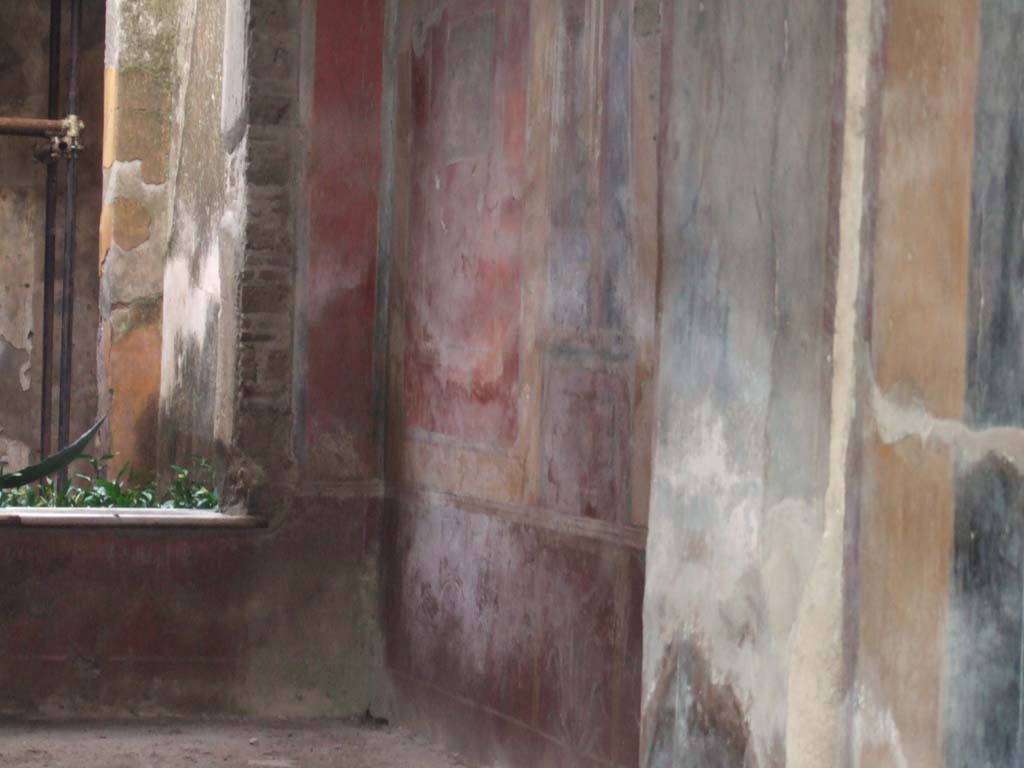 I.7.3 Pompeii. December 2005. West wall of atrium.
According to Peters, on the left of the west wall was a well-preserved (in 1963) landscape.
He considered the painting very picturesque.
The subject was a temple with a curved roof, standing on a hill against which a tree was growing.
See Peters, W.J.T. (1963): Landscape in Romano-Campanian Mural Paintings. The Netherlands, Van Gorcum & Comp. (p. 153 & fig. 147)
The approximate area of the painting can be seen in the south-west corner, in the upper part of the photo, left of centre.