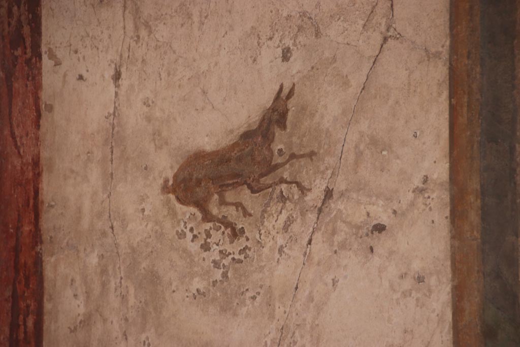 I.7.11 Pompeii. October 2023.
South wall of exedra at east end, detail of painted decoration in centre of panel. Photo courtesy of Klaus Heese.
