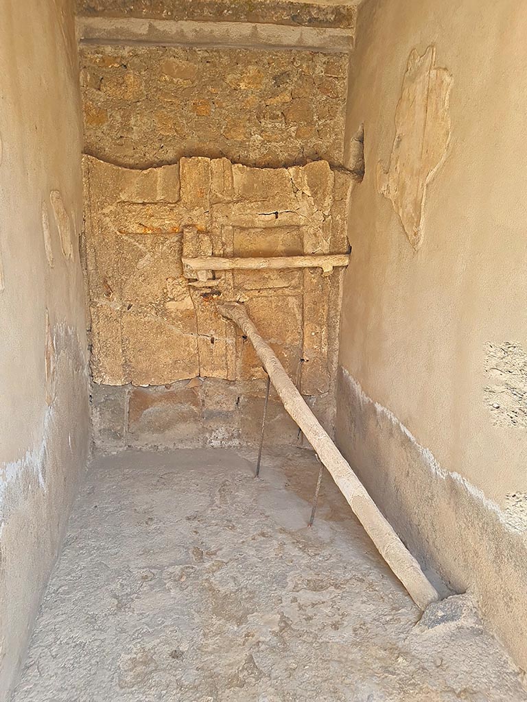 I.7.10/11 Pompeii. September 2024. Detail of the blocked entrance at I.7.10.
Detail of cement cast of door with two shutters reinforced with a horizontal crossbar and a pole positioned into a hollow in the floor.
Photo courtesy of Giuseppe Ciaramella.